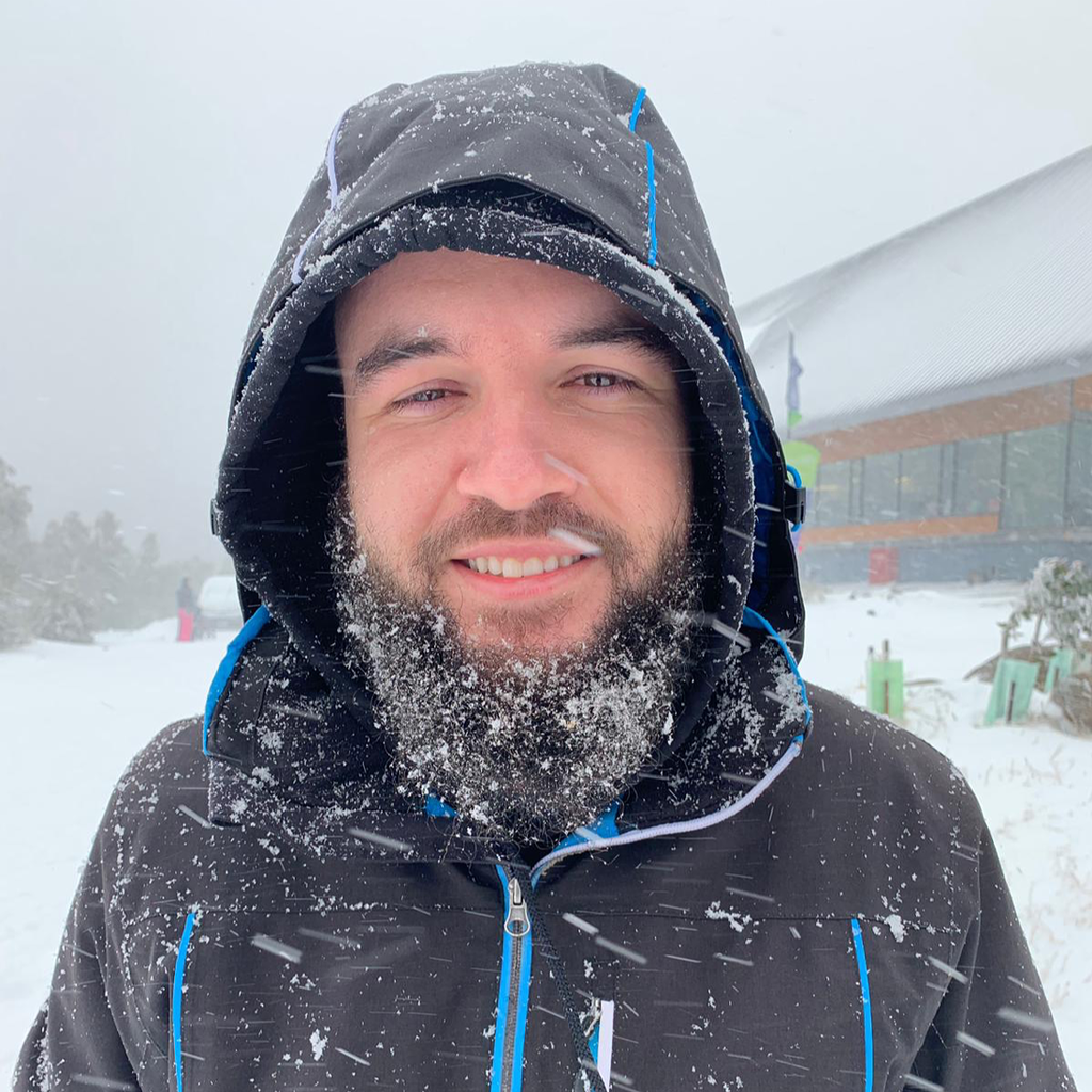 Caio smiling in the snow, wearing a winter jacket